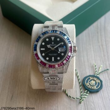 Rolex GMT-Master II Rainbow Iced Out super clone ETA 40mm com bezel cravejado de safiras azuis e rubis vermelhos, mostrador preto e pulseira Oyster totalmente cravejada com diamantes e baguetes, apresentado em suporte branco com caixa verde Rolex ao fundo